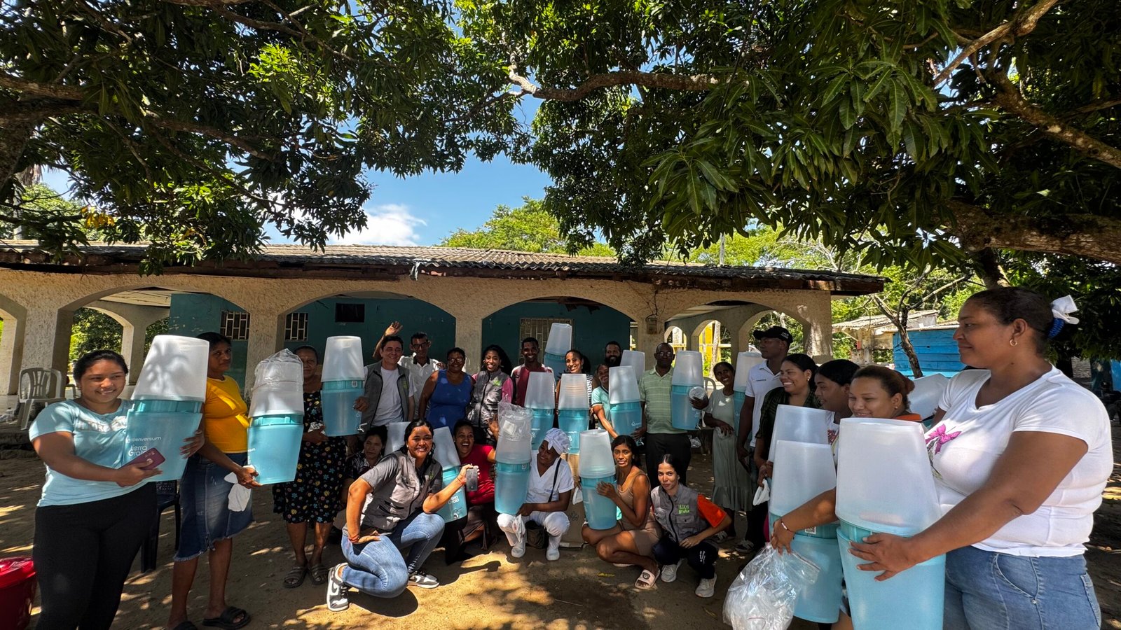 Habitantes de Casa Japón reunidos al aire libre sosteniendo filtros de agua.